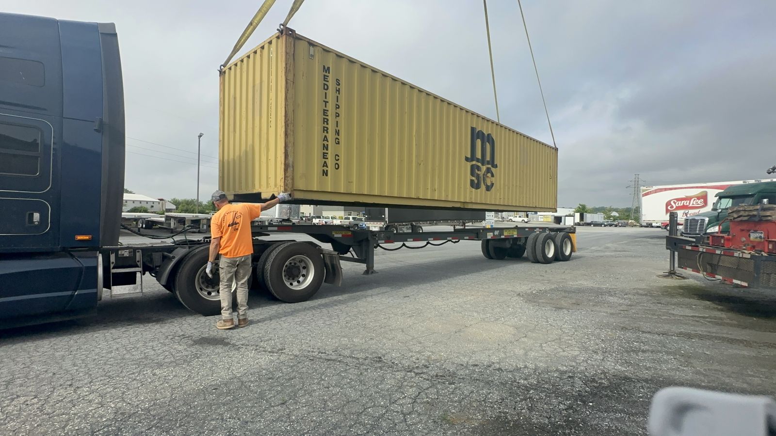 Shipping container being loaded onto a truck chassis by crane