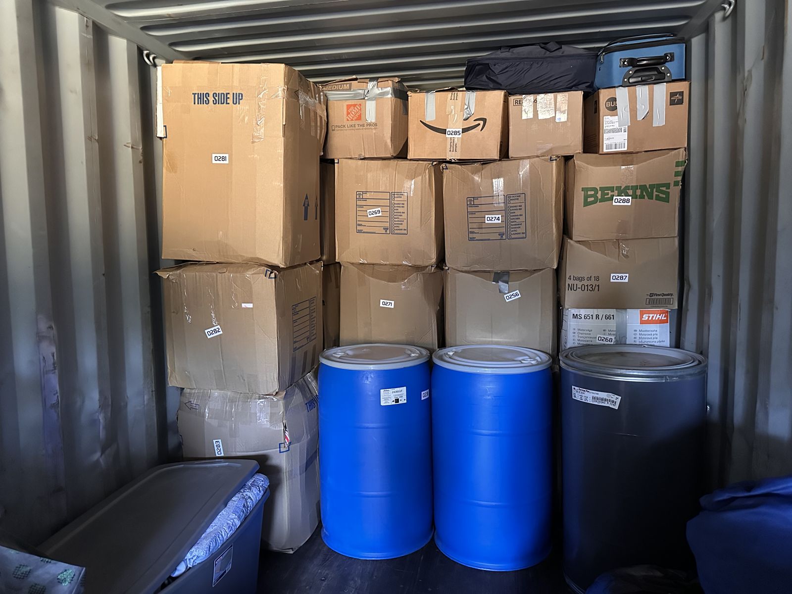 Customer boxes and drums packed and labeled inside a Big Five Shipping container